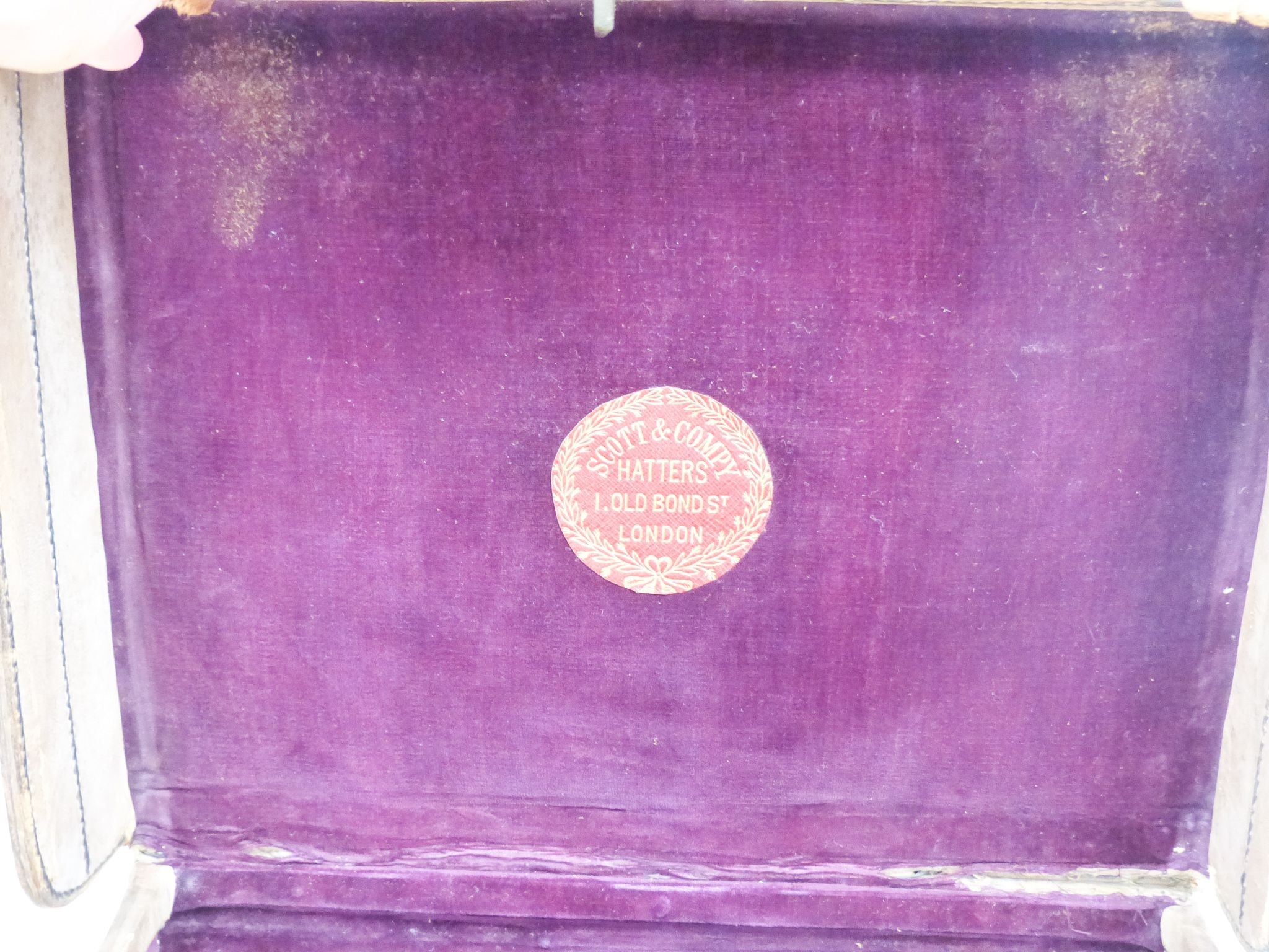 A Scott & Company brown leather case containing a grey top hat